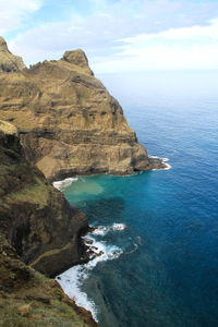 Rock formations by sea against sky