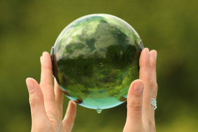 Close-up of human hand holding crystal ball