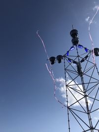 Low angle view of illuminated ferris wheel against blue sky