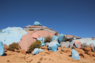 Rock formations on landscape against clear blue sky