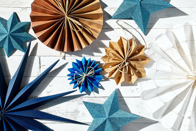 Winter holiday decoration. paper snowflakes, paper blue stars and fans made of craf paper