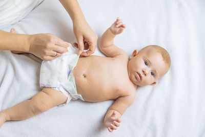 High angle view of baby girl lying on bed at home