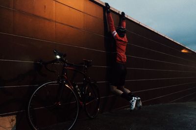 Man standing on bicycle against sky