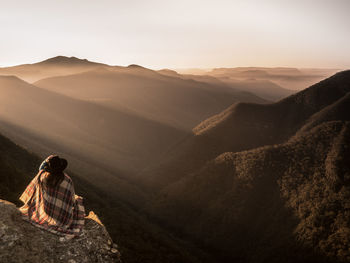 Rear view of woman looking at mountains against sky