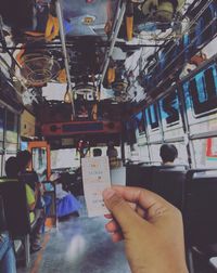 Midsection of man holding hands in bus