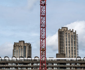 Low angle view of crane against cloudy sky