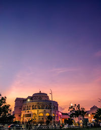 Buildings in city against sky during sunset