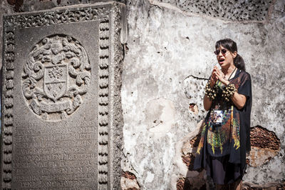 Woman standing by wall