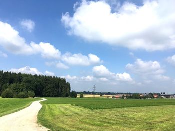 Scenic view of grassy field against cloudy sky