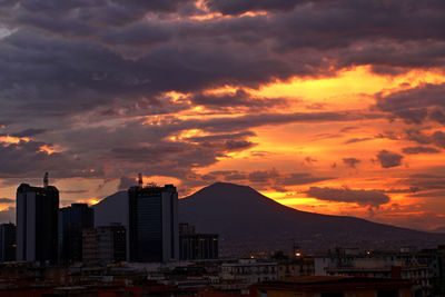 Modern buildings in city against sky during sunset