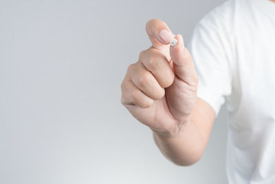 Close-up of person holding hands over white background