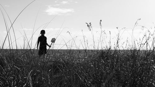 Silhouette man standing on field against sky