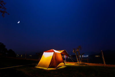 Tent on field against clear sky at night