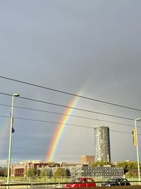 Low angle view of rainbow over buildings against clear sky