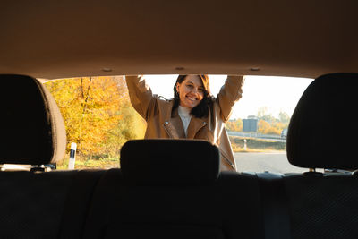 Portrait of young woman sitting in car