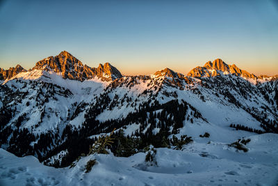 Scenic view of snow covered mountains against sky during sunset