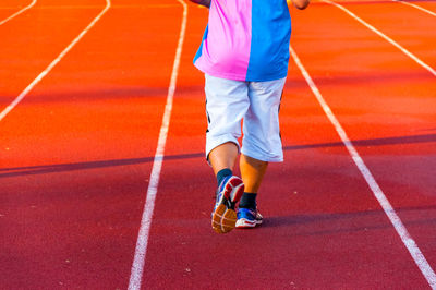 Low section of man running on track