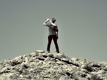 Full length of young woman standing against sky