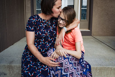 Rear view of mother and girl sitting at home