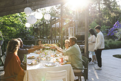 Family and friends enjoying summer dinner at patio in back yard