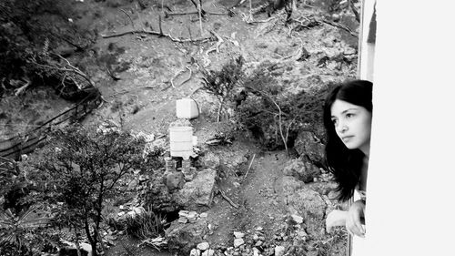 Portrait of young woman standing by plants