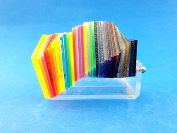 High angle view of multi colored pencils on table against blue background