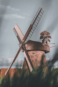 Low angle view of traditional windmill against sky