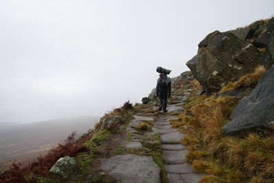 Rear view of people on rock against sky