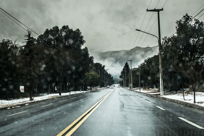 Road amidst trees against sky