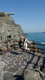 Cheerful woman jumping against sea