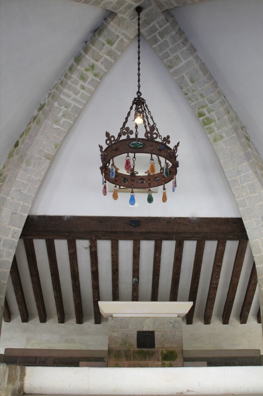 LOW ANGLE VIEW OF CROSS HANGING ON CEILING IN BUILDING