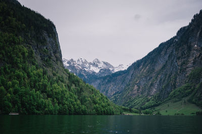 Scenic view of lake by mountains against sky