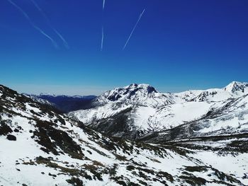 Scenic view of snowcapped mountains against clear blue sky