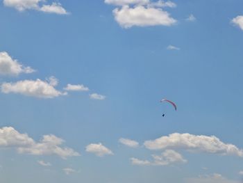 Low angle view of person paragliding against sky