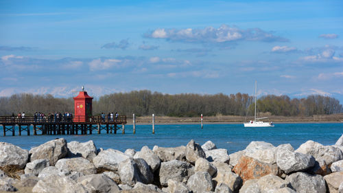 Lighthouse by sea against sky