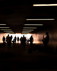 Silhouette people standing in illuminated room