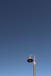 Low angle view of old-fashioned street light against clear blue sky in daytime with large copy space