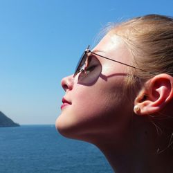 Close-up of young woman in sea against clear sky