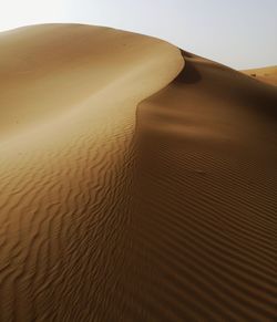 Sand dune in desert against sky