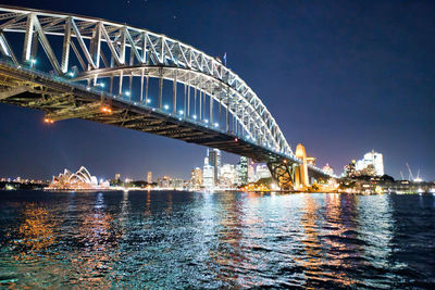 View of bridge over river at night