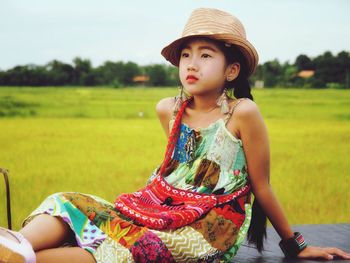 Portrait of happy woman sitting on field