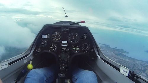 Close-up of airplane flying over sea against sky