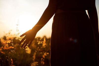 Silhouette woman against sky during sunset