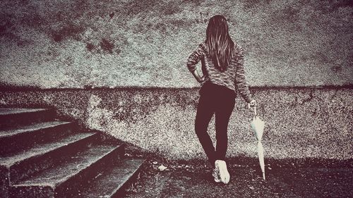 Woman with umbrella standing against blurred background