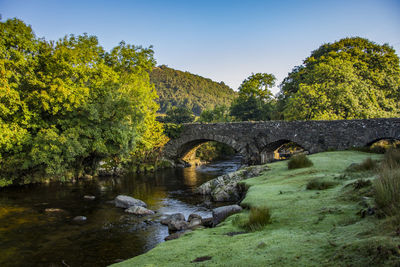 Arch bridge over river against sky