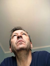 Low angle view of man looking away against ceiling