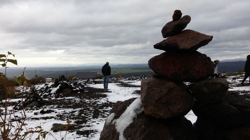Rear view of people on beach against sky