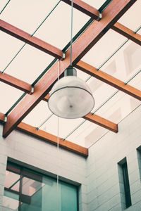 Low angle view of pendant light hanging on wall in building