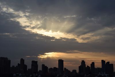 Silhouette buildings against sky during sunset