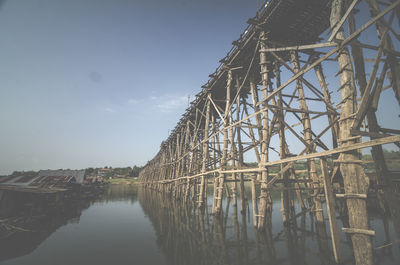 Low angle view of bridge over river against sky